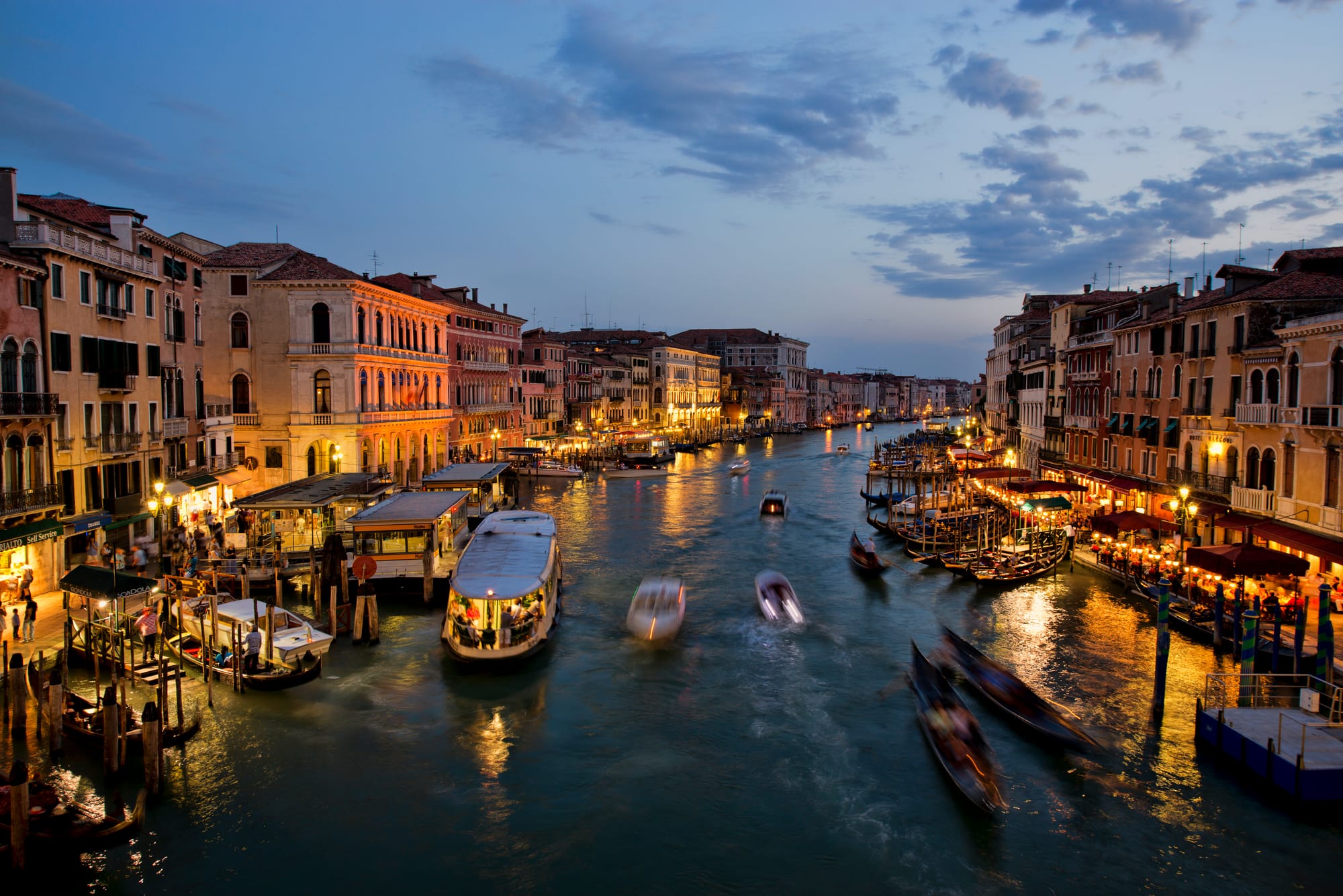The Grand Canal in Venice at dusk, lit palazzi and boats